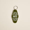 Olive green LMTC motel-style keychain with a leaf pattern