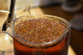 Cup of Rugger's Rooibos tea by Lake Missoula Tea Company, steaming in a glass mug with a rich, reddish-brown color.