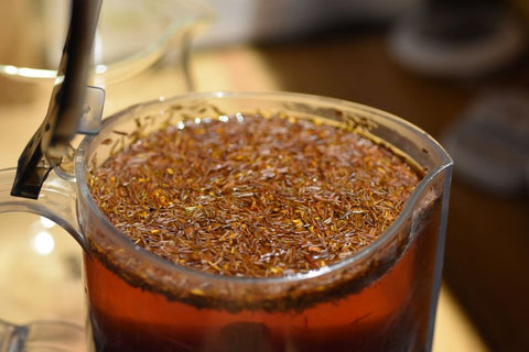 Cup of Rugger's Rooibos tea by Lake Missoula Tea Company, steaming in a glass mug with a rich, reddish-brown color.