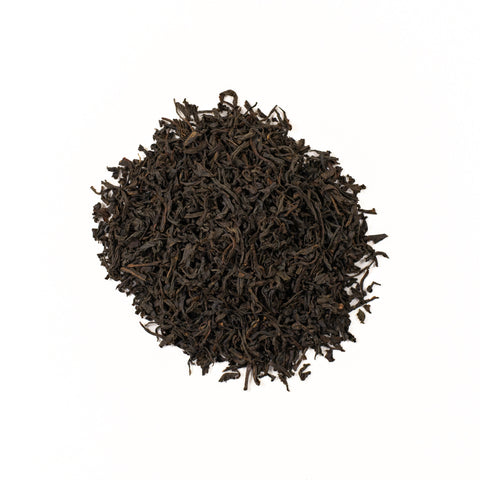 Loose leaf Dom Dom Assam tea from Lake Missoula Tea Company, showing dark amber tea leaves in a clear glass jar.