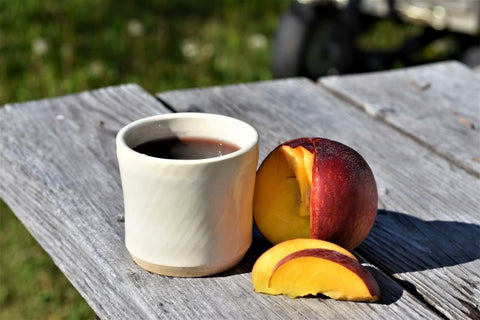 Sliced cup of Pleistocene Peach tea by Lake Missoula Tea Company in a clear glass mug, showcasing the peach-flavored herbal tea.