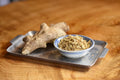 Ginger Orange Puerh tea in a cup with ginger root and orange slices, served on a wooden table, by Lake Missoula Tea Company.