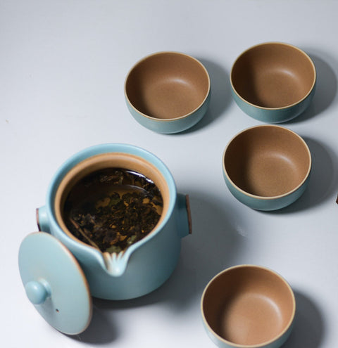 Light blue background with a package of Lake Missoula Tea Company's roasted Tie Guan Yin tea leaves in minimalist packaging.