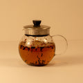A cup of Rose Chai tea from Lake Missoula Tea Company with rose petals and chai spices in a ceramic mug.