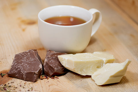 Lake Missoula Chocolate Love tea in a teacup with chocolate pieces and tea leaves, showcasing the flavorful chocolate tea blend.