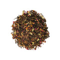 Glass cup of Lake Missoula Tea Company's Rose Chai with rose petals and spices, served hot in a clear glass mug.