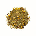 A cup of Lake Missoula Tea Company's Evening in Missoula herbal tea with dried herbs and flowers in a rustic setting.