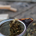 Cup of Lake Missoula Tea Company's Licorice Mint tea in a clear glass mug, showing a dark herbal infusion with fresh mint leaves.