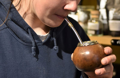 Yerba Maté tea from Lake Missoula Tea Company in a traditional gourd with a metal straw on a wooden table.