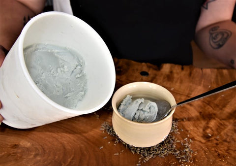 Lavender Lift tea by Lake Missoula Tea Company, featuring fresh lavender blooms in a clear glass teacup on a wooden surface.