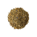 Lake Missoula Tea Company Zen Cleanse tea in a clear glass cup with loose herbal tea leaves and fresh herbs.