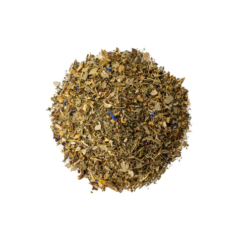 Lake Missoula Tea Company Zen Cleanse tea in a clear glass cup with loose herbal tea leaves and fresh herbs.