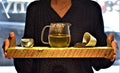 Jasmine Green tea in a cup with a teapot, displayed on a wooden board, from Lake Missoula Tea Company.