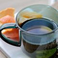 Empress Grey tea by Lake Missoula Tea Company shown in a teacup with loose grey tea leaves and a rainy grey background.