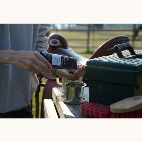 Loose leaf Honey Ponderosa tea by Lake Missoula Tea Company being poured into a cup, showcasing golden honey-colored tea leaves.
