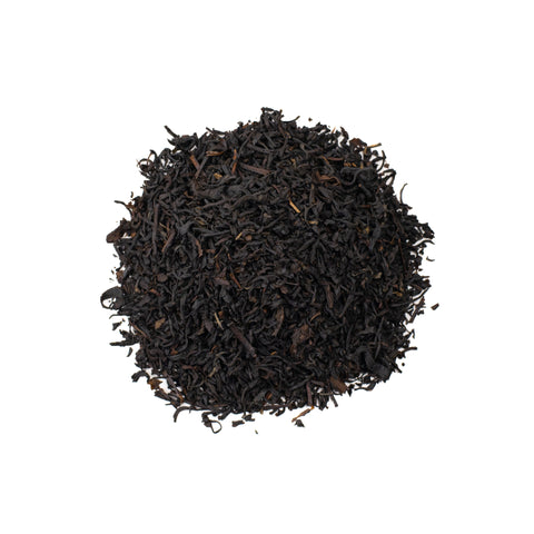 Cup of Lake Missoula Tea Company's Vanilla Crème tea in a white mug, with vanilla beans and tea leaves on a wooden surface.