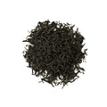 Dry Royal Lapsang tea leaves from Lake Missoula Tea Company in a clear glass jar, showcasing their dark, smoky appearance.