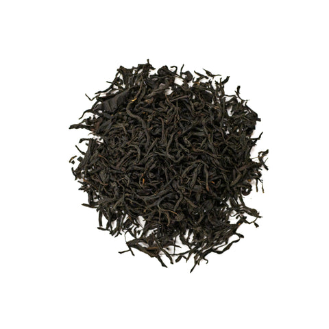 Dry Royal Lapsang tea leaves from Lake Missoula Tea Company in a clear glass jar, showcasing their dark, smoky appearance.