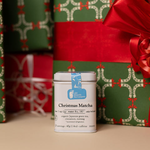 Christmas Matcha tea from Lake Missoula Tea Company with festive presents and holiday decorations in a cozy setting.