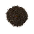 Cup of Birdsong Black tea from Lake Missoula Tea Company in a white teacup with tea leaves beside it.