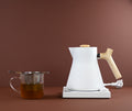 White ceramic tea cup filled with brewed Ginkgo Brain Tea by Lake Missoula Tea Company, placed on a wooden table.