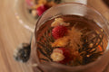 Flowering Tea Double Happiness by Lake Missoula Tea Company, blooming tea ball in a clear glass cup showcasing its floral display.