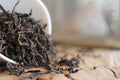 A cup of Royal Lapsang tea from Lake Missoula Tea Company showing dark brewed tea in a cup with a tea bag and saucer.