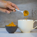 Golden Milk tea from Lake Missoula Tea Company in a clear glass cup with warm, golden-colored liquid and a cinnamon stick garnish.