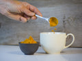 Golden Milk tea from Lake Missoula Tea Company in a clear glass cup with warm, golden-colored liquid and a cinnamon stick garnish.