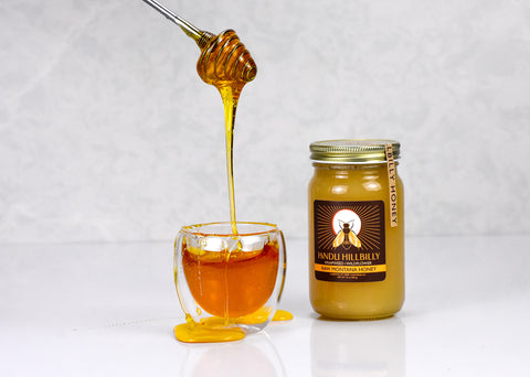 Raw Montana honey in a teaware container from Lake Missoula Tea Company, featuring a natural honey dipper and rustic packaging.