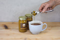 Cup of Lake Missoula Tea Company peppermint tea with honey in a glass mug, showcasing fresh peppermint leaves and honey drizzle.