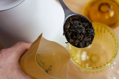 Horizontal image of Lake Missoula Tea Company's Mammoth Red herbal tea in a clear glass cup with a tea bag and vibrant red tea leaves.