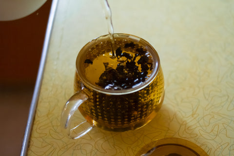 Horizontal image of Lake Missoula Tea Company's Ginseng Oolong tea package with tea leaves, showcasing the product's natural packaging.