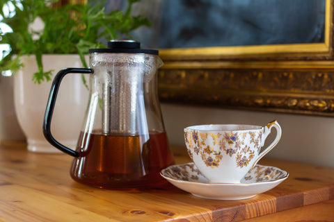 Cup of Lake Missoula Tea Company's cinnamon orange spice tea in a white mug, with cinnamon sticks and orange slices on a wooden table.