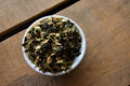 Loose leaf Jurassic Ginger Green tea from Lake Missoula Tea Company, showcasing vibrant green tea leaves and ginger pieces.