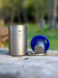 Keith titanium mug with blue lid and silver kettle on a natural background