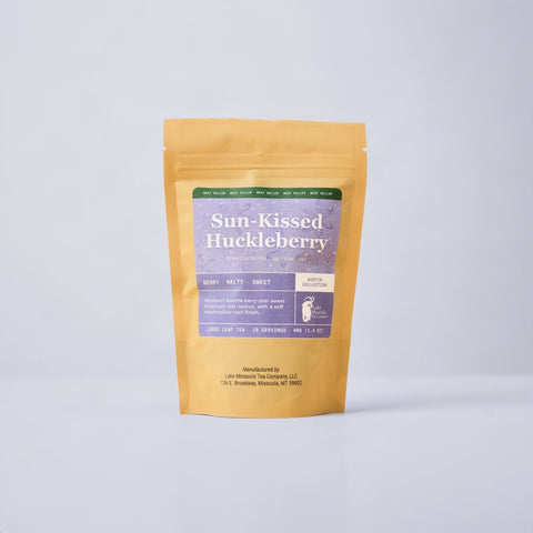 Sun Kissed Huckleberry 2oz bag with colorful label on blue background.