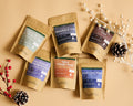 Assortment of Lake Missoula Tea Company tea pouches arranged with pinecones and red berries