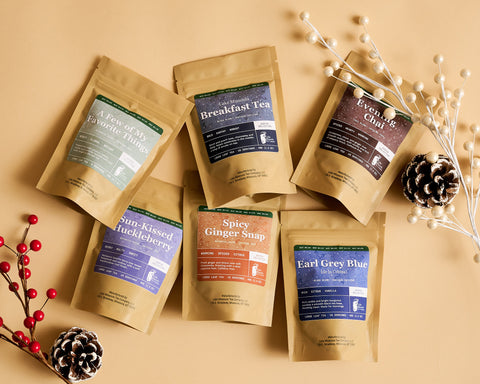 Assortment of Lake Missoula Tea Company tea pouches arranged with pinecones and red berries