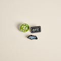 Three Lake Missoula Tea Company enamel pins: In My Tea Era, Drink Tea Read Books, and Mammoth