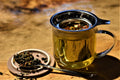 Cup of Mimosa Oolong tea from Lake Missoula Tea Company, showing a brewed golden tea in a clear glass cup with a tea bag tag.