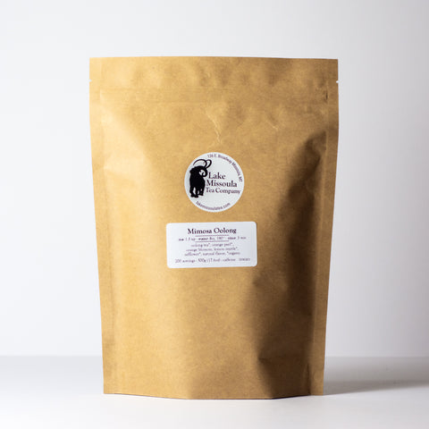 Loose-leaf Mimosa Oolong tea from Lake Missoula Tea Company in a 500g package, showcasing golden rolled leaves and aromatic blend.