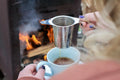 Big Sky Black Scottish Breakfast tea in a teacup with outdoor fireplace scene at sunset, showcasing a cozy tea experience outdoors.