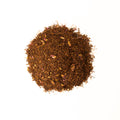 Cup of Rooibos Rose tea from Lake Missoula Tea Company with dried rooibos and rose petals in a teacup.