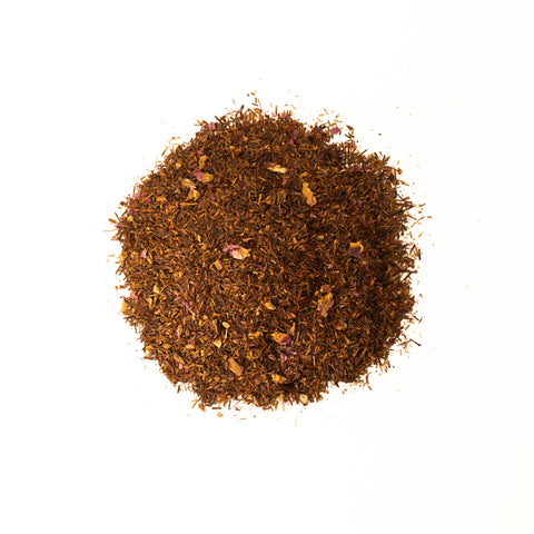 Cup of Rooibos Rose tea from Lake Missoula Tea Company with dried rooibos and rose petals in a teacup.