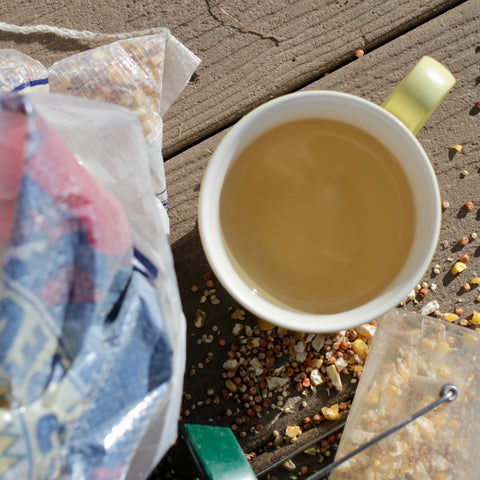 Fresh brewed oatstraw tea in a clear glass cup, showcasing its light golden color and delicate herbal aroma.