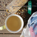 Early spring Chrysanthemum Flower Tea from Lake Missoula Tea Company in a clear glass teapot with blooming yellow chrysanthemums.