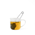 Lake Missoula Tea Company tea strainer with handle resting in a cup, showcasing fine mesh for brewing loose leaf tea.