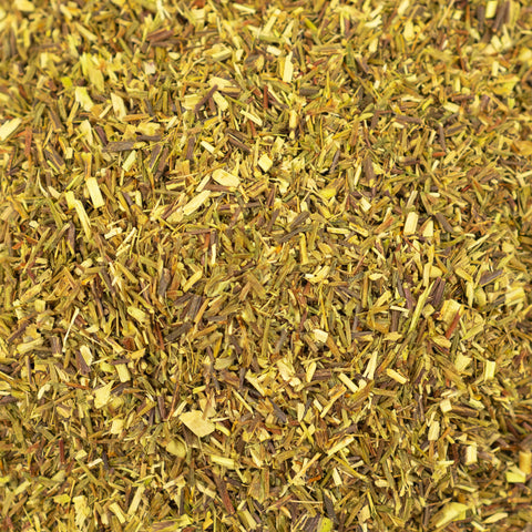 Close-up of dried green rooibos tea leaves showing their fine, textured green and reddish-brown hues from Lake Missoula Tea Company.