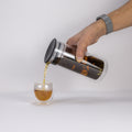 Clear glass Viva Minima tea carafe from Lake Missoula Tea Company pouring tea, showcasing elegant teaware design.